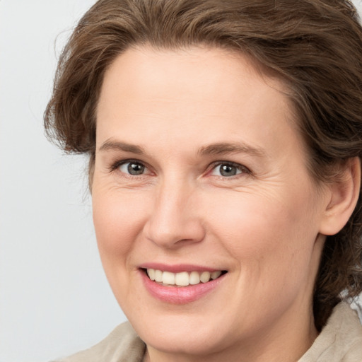 Joyful white adult female with medium  brown hair and grey eyes