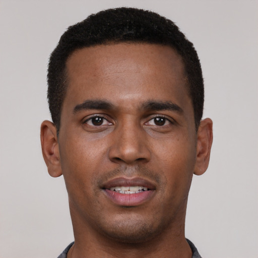 Joyful black young-adult male with short  black hair and brown eyes