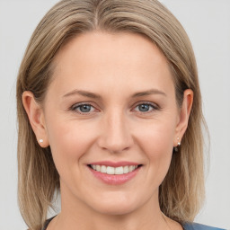 Joyful white young-adult female with medium  brown hair and blue eyes