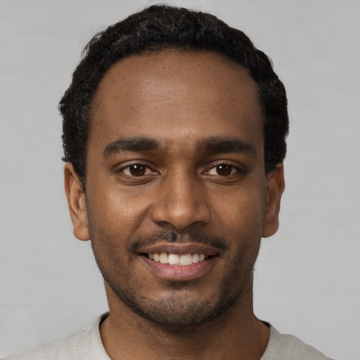 Joyful black young-adult male with short  black hair and brown eyes