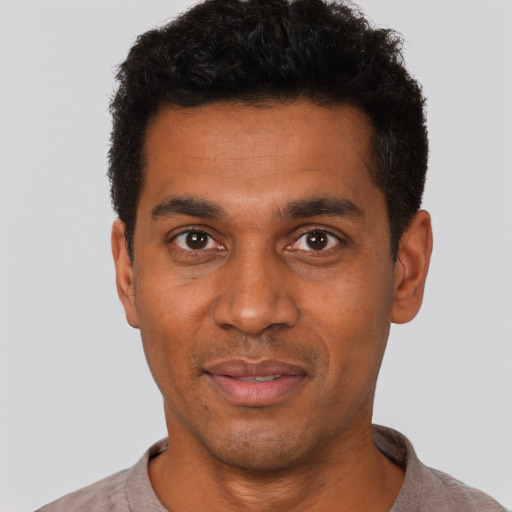 Joyful black young-adult male with short  black hair and brown eyes