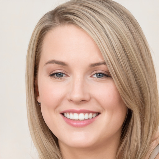 Joyful white young-adult female with long  brown hair and blue eyes