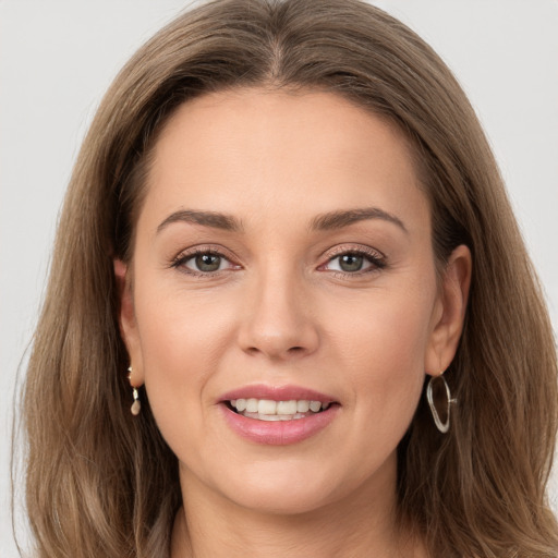 Joyful white young-adult female with long  brown hair and grey eyes