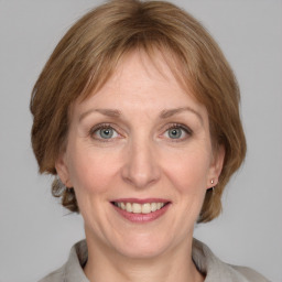 Joyful white adult female with medium  brown hair and grey eyes