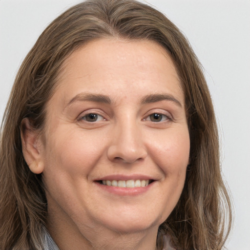 Joyful white adult female with long  brown hair and brown eyes