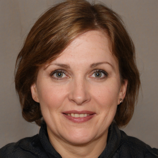 Joyful white adult female with medium  brown hair and grey eyes