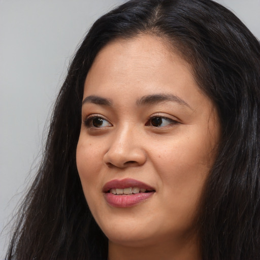 Joyful asian young-adult female with long  black hair and brown eyes