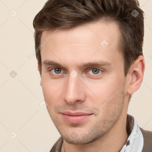 Joyful white young-adult male with short  brown hair and grey eyes