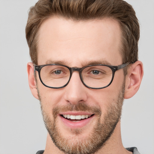 Joyful white young-adult male with short  brown hair and grey eyes