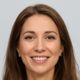 Joyful white young-adult female with long  brown hair and green eyes