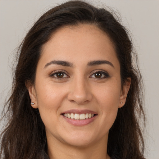 Joyful white young-adult female with long  brown hair and brown eyes