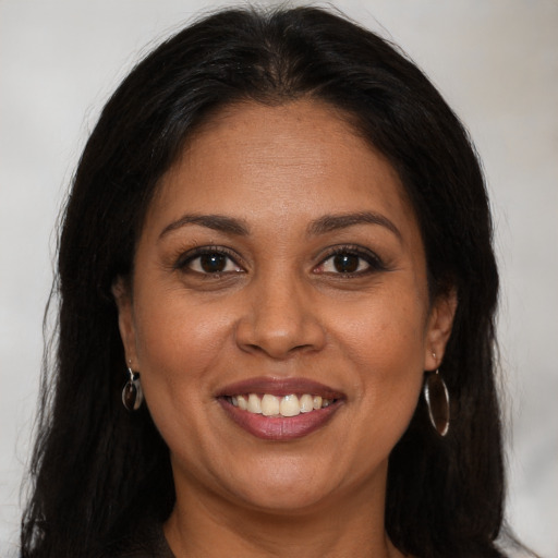 Joyful black young-adult female with long  brown hair and brown eyes