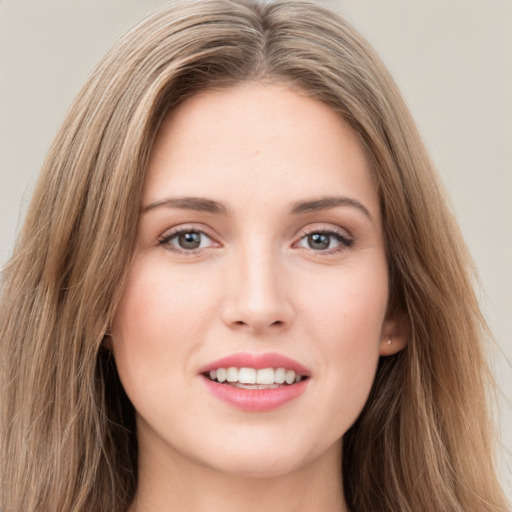 Joyful white young-adult female with long  brown hair and green eyes