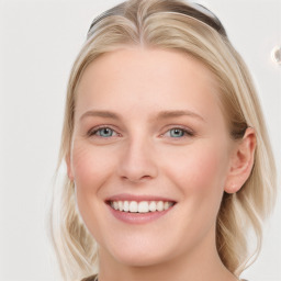 Joyful white young-adult female with long  brown hair and blue eyes