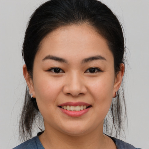 Joyful asian young-adult female with medium  brown hair and brown eyes