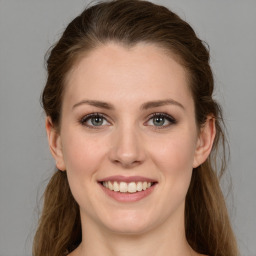 Joyful white young-adult female with long  brown hair and green eyes