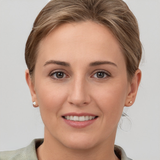 Joyful white young-adult female with short  brown hair and grey eyes