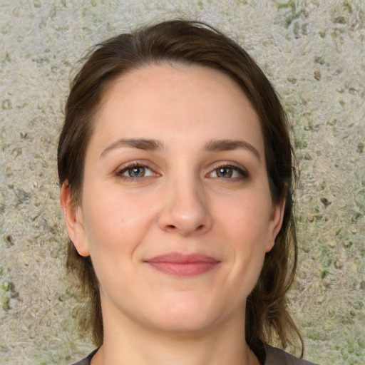 Joyful white young-adult female with medium  brown hair and green eyes