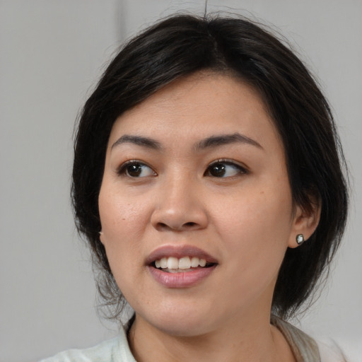 Joyful asian young-adult female with medium  brown hair and brown eyes