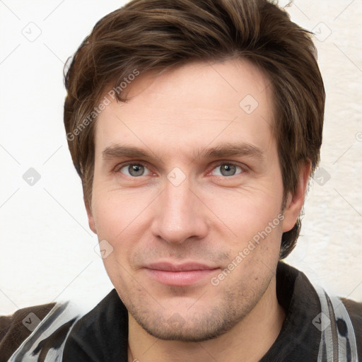 Joyful white young-adult male with short  brown hair and grey eyes