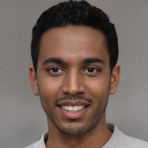 Joyful black young-adult male with short  black hair and brown eyes