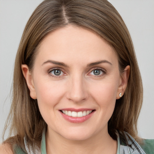 Joyful white young-adult female with medium  brown hair and grey eyes