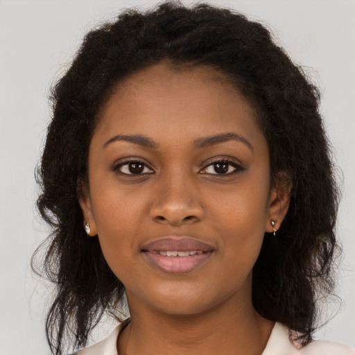 Joyful black young-adult female with long  brown hair and brown eyes