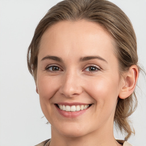 Joyful white young-adult female with medium  brown hair and grey eyes