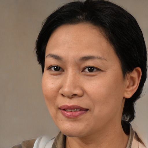 Joyful asian adult female with medium  brown hair and brown eyes