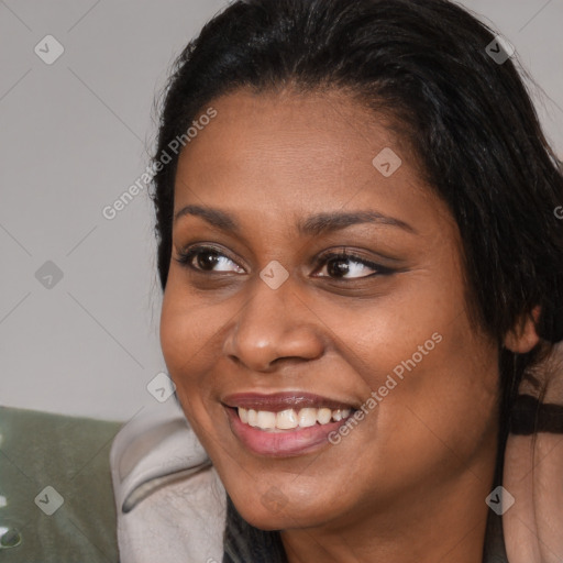 Joyful black young-adult female with long  brown hair and brown eyes