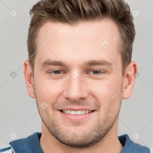 Joyful white young-adult male with short  brown hair and grey eyes