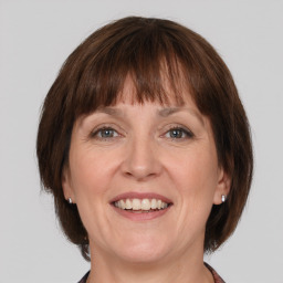 Joyful white adult female with medium  brown hair and grey eyes