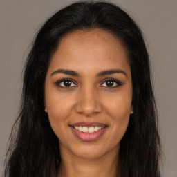 Joyful latino young-adult female with long  brown hair and brown eyes