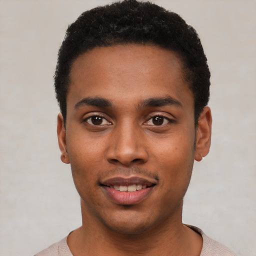 Joyful black young-adult male with short  black hair and brown eyes