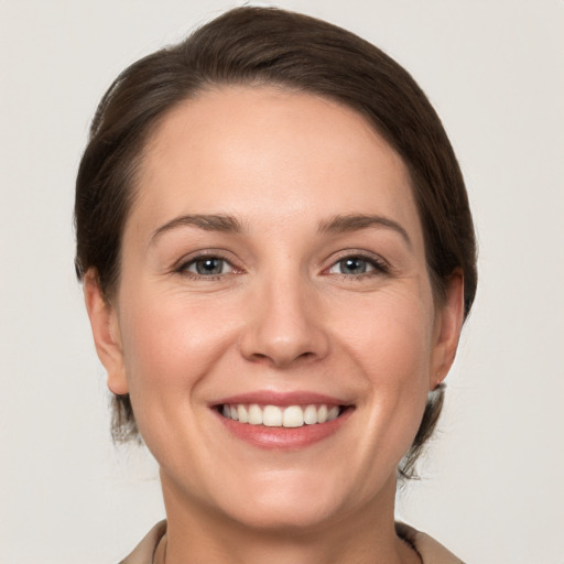 Joyful white young-adult female with medium  brown hair and grey eyes