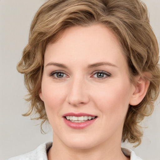 Joyful white young-adult female with medium  brown hair and green eyes