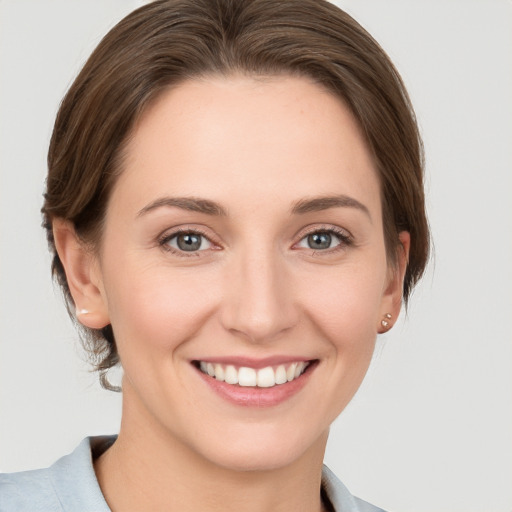 Joyful white young-adult female with medium  brown hair and grey eyes