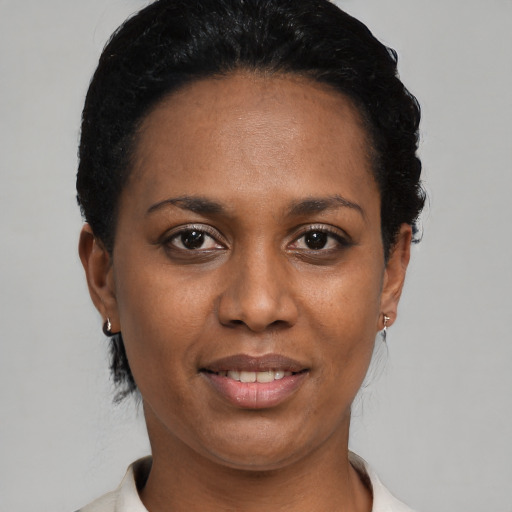 Joyful black young-adult female with short  black hair and brown eyes
