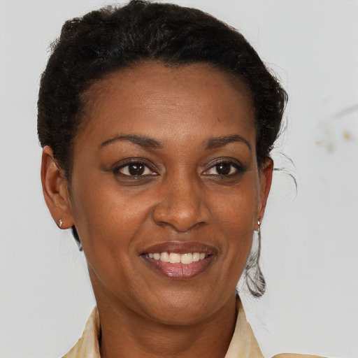 Joyful black adult female with short  brown hair and brown eyes