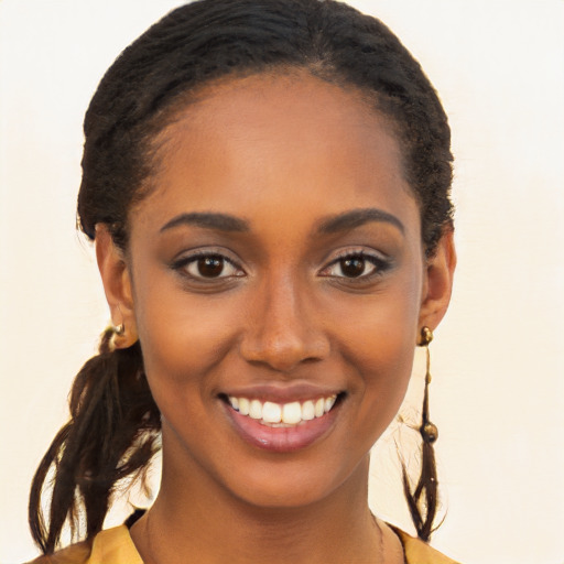 Joyful black young-adult female with long  brown hair and brown eyes