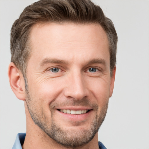 Joyful white adult male with short  brown hair and grey eyes