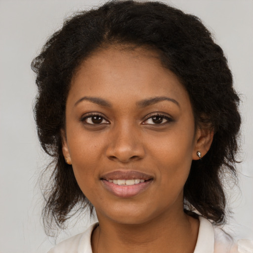 Joyful black young-adult female with medium  brown hair and brown eyes