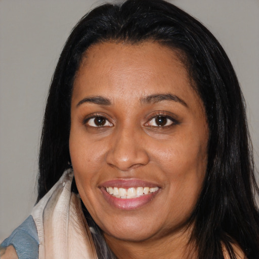 Joyful latino adult female with medium  black hair and brown eyes