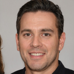 Joyful white adult male with short  brown hair and brown eyes