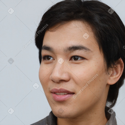 Joyful asian young-adult male with medium  black hair and brown eyes