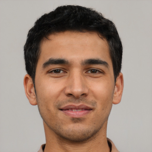 Joyful latino young-adult male with short  black hair and brown eyes