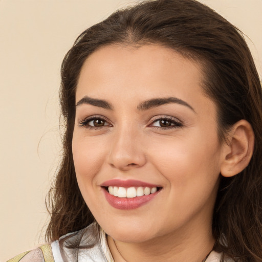 Joyful white young-adult female with long  brown hair and brown eyes