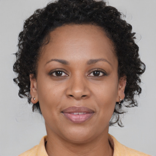 Joyful black adult female with medium  brown hair and brown eyes