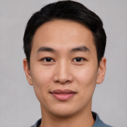 Joyful asian young-adult male with short  black hair and brown eyes