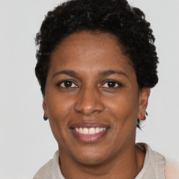 Joyful black adult female with short  brown hair and brown eyes